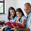 Father and mother reading a book for daughter