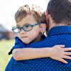 Father holding in his arms a hearing impaired boy