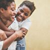  Son hugging mother from back and smiling