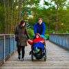 Mother and father pushing their wheelchair child and smiling