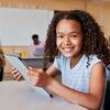 Student girl holding a tablet in her hand and smiling