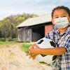 Boy wear a mask and hold a soccer ball in his hand