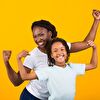 Mother and daughter showing muscle before a yellow background