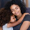 Mother and daughter hugging while they close their eyes