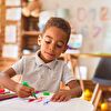 Boy drawing with colored pencil