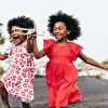 Two girl running and playing with a plane