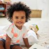 Baby girl sitting on the ground and smiling