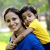 Boy hanging on her mother's back