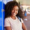 Teenager girl leaning on the blue closet and smiling