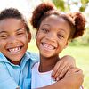 Siblings hugging each other and smiling