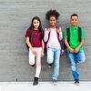 Three students staying before a wall