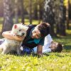 Boy playing with white dog on the ground