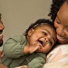 Mother, father and baby smiling