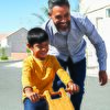 Father assisting son learning cycle