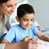 Mother assisting learning son