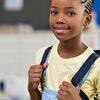 Boy wearing a school bag and smiling