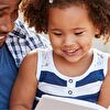 Father and daughter reading a book and smiling